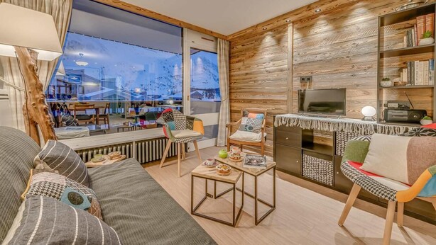Een moderne woonkamer met een groot raam, een open haard en een boekenkast.
