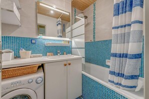 A compact bathroom with a washing machine, a sink, and a shower area. - 300m from resort center, 4th floor, balcony, tv, ski locker, 39m², Tignes (Tignes)