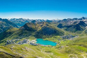 An aerial view of a mountainous area with a small town and a turquoise lake. - 300m from resort center, 4th floor, balcony, tv, ski locker, 39m², Tignes (Tignes)