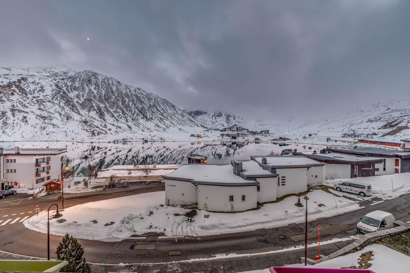 A snow-covered mountain town with buildings and a road.