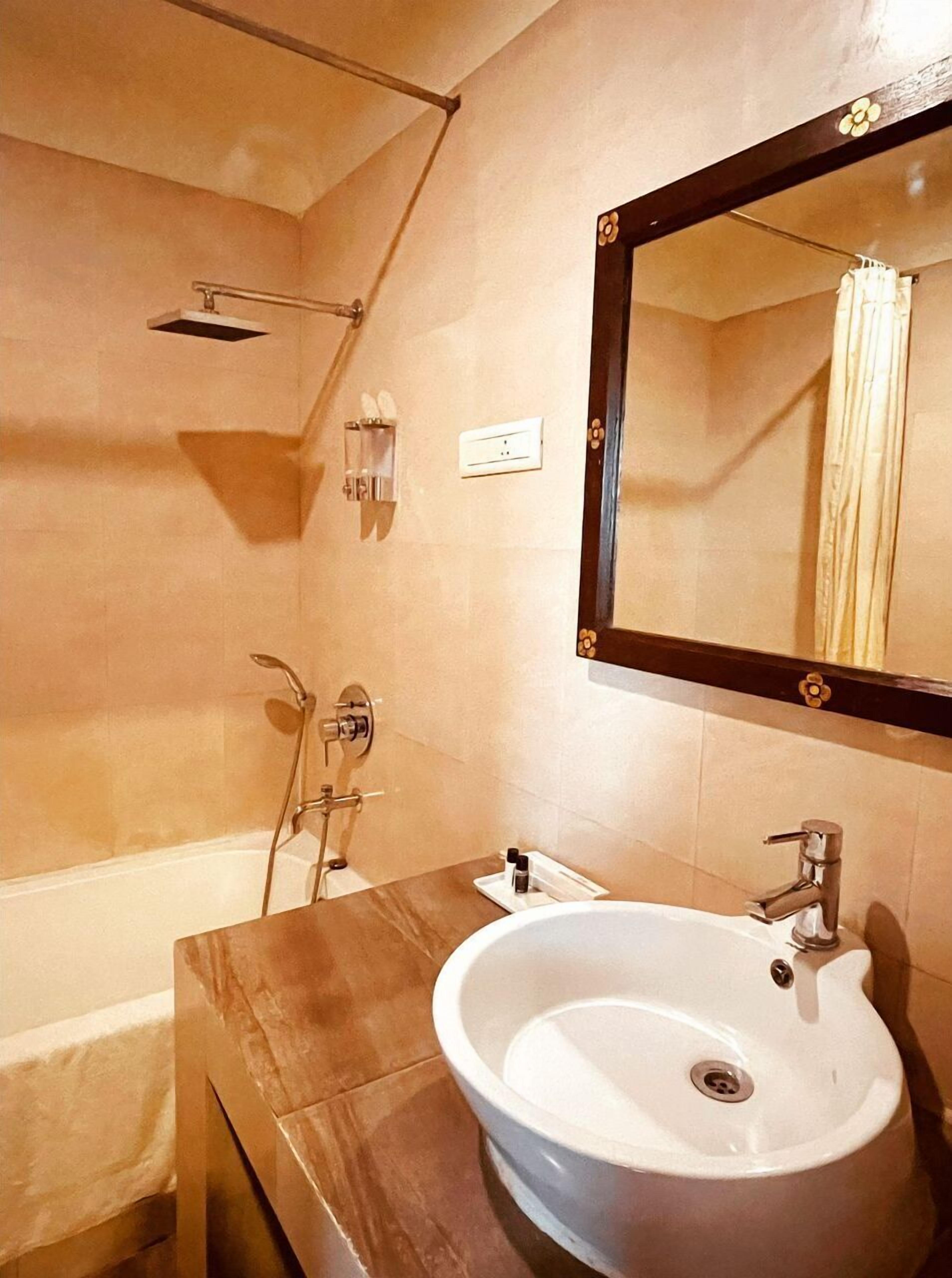 A bathroom with a bathtub, a sink, a shower, and a mirror.