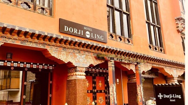 Een traditioneel gebouw met een bord waarop 'Hotel Dorji-Ling' staat.