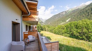 Una terraza de madera con vista a un paisaje montañoso.