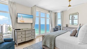 A bedroom with a large bed, a dresser, a TV, and a view of the ocean. - Spectacular Beachfront Penthouse at Jade East Towers (Destin)