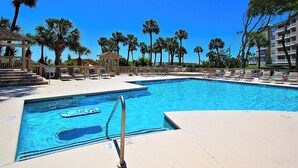 A swimming pool with lounge chairs and palm trees. - Direct Ocean Front Views from the 4th Floor (Hilton Head Island)