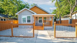 A single-story house with a porch, a small front yard, and a wooden fence. - Don't Miss Dynamic 4BR/2BA Near Jolly Riverwalk (San Antonio)