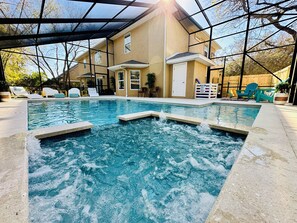 Una piscina con una casa al fondo.
