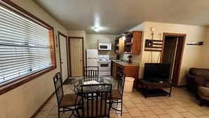 Un espace de vie compact comprenant un coin repas, une kitchenette et un coin salon.