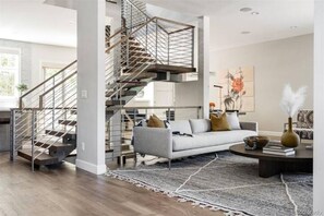 Stunning living area with a grand staircase, comfortable sofa, and modern decor.