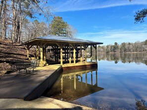 A wooden gazebo with a metal roof overlooking a calm lake, surrounded by trees. - Experience Lake Tuscaloosa views from your 5-bedroom Northport retreat (Northport)