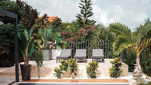 A swimming pool with lounge chairs and tropical plants. - Villa Azuréa Piscine et Plages (Sainte-Anne)