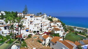 A coastal village with white buildings, terracotta roofs, and a clear view of the sea. - Capistrano Playa Apt 610 | CG R795 (Nerja)