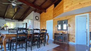 A spacious dining area with a wooden table and chairs, a ceiling fan, and a rustic wooden interior. - Huron waterfront cottage/Hot tub/max2 pets for16+people with private sand beach  (Goderich)