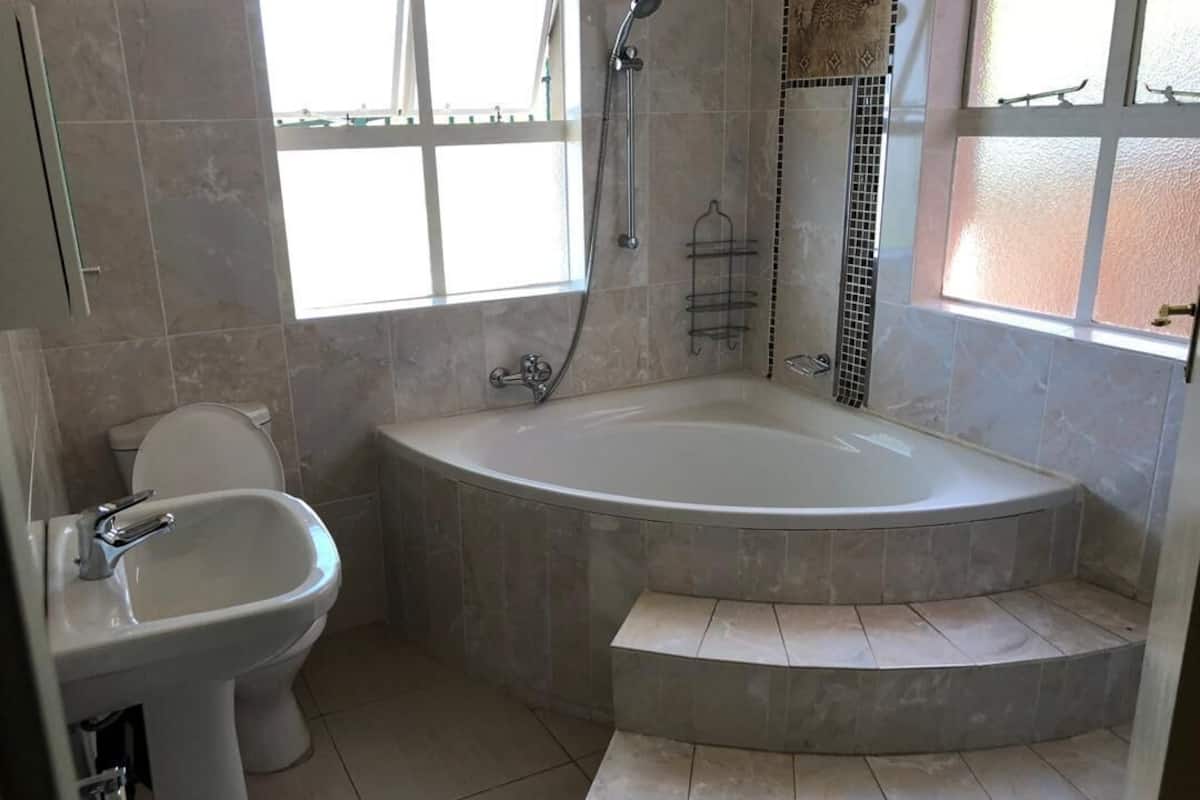 Une salle de bain avec une baignoire sur pieds, un lavabo sur colonne et des toilettes.