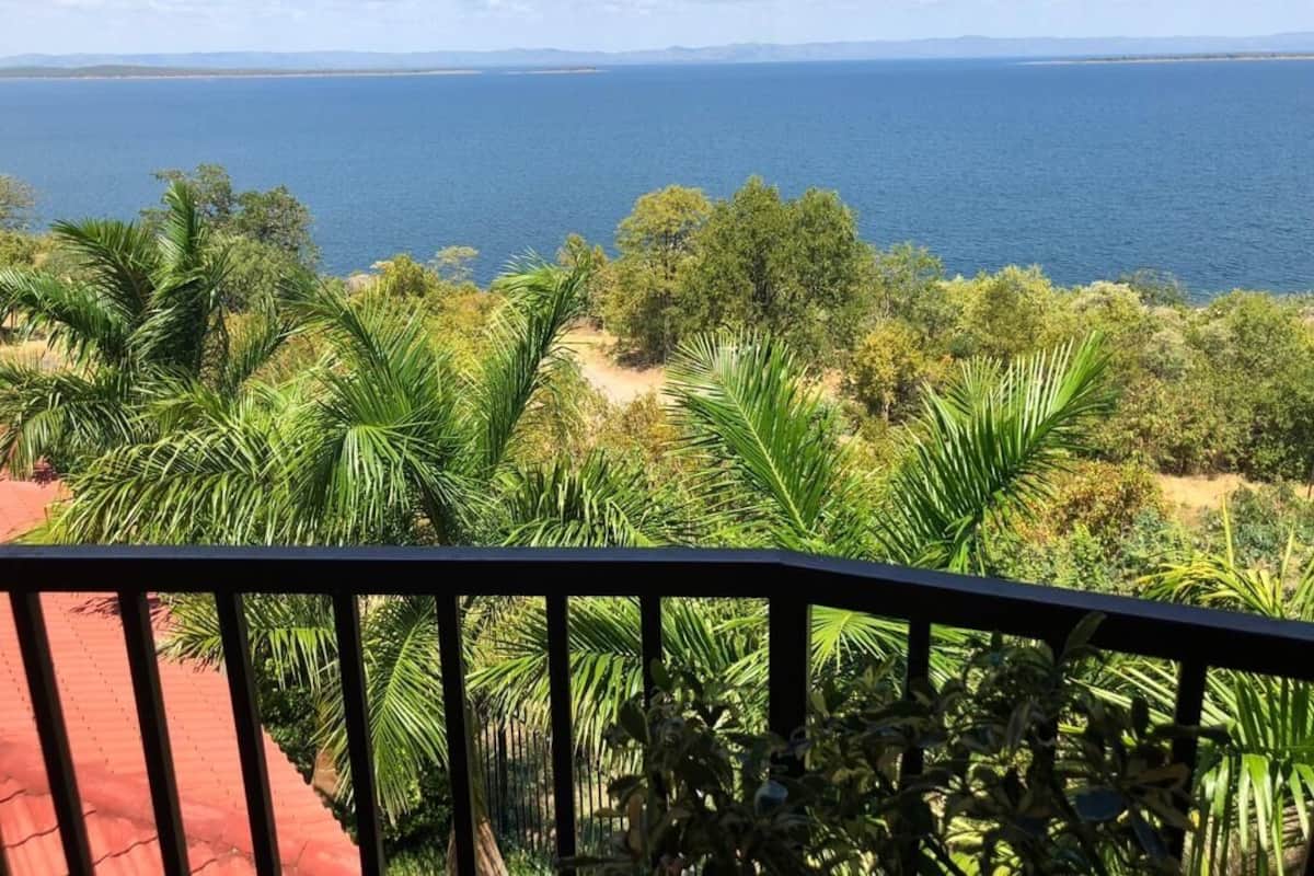 Un balcon avec vue sur la mer et la végétation environnante.