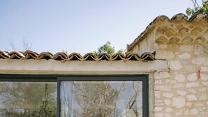 A stone building with a large glass window and a dog sitting on the steps. - The Aviary - Pernes-les-Fontaines (Pernes-les-Fontaines)