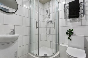 A modern bathroom with a glass-enclosed shower, a white sink, and a toilet. - Studio 4 in Coventry (Coventry)