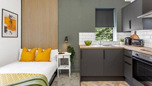 A compact kitchen with a sink, stove, and a window. - Studio 8 in Nottingham (Nottingham)