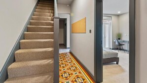 A staircase with carpeted steps leading to a room with a patterned floor. - Room 5 25 Meriden Street (Coventry)