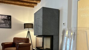 Ein gemütliches Wohnzimmer mit Kamin, Ledersofa und Couchtisch.