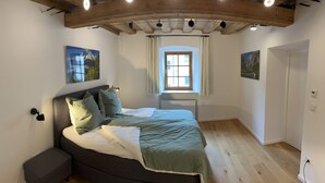 Ein Schlafzimmer mit einem Bett, einem Fenster und zwei Bildern an der Wand.