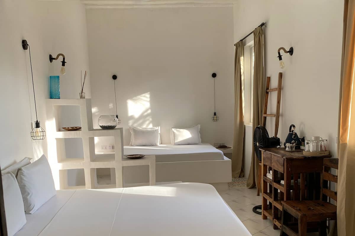 Un dormitorio amplio con una cama grande, un aparador de madera, un escritorio y una silla.