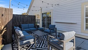 An outdoor patio with a sofa set, a patterned rug, and string lights. - Spacious | Balcony | Central | Hosted By StayRafa (Newtown)