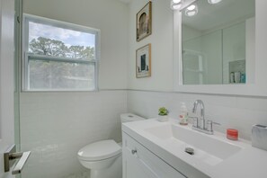 A modern bathroom with a toilet, sink, and mirror.