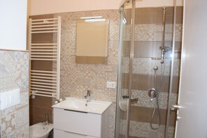 Een douche, een haardroger, een bidet, handdoeken