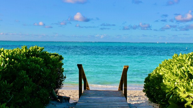 A wooden pathway leading to a beach with clear turquoise water and a clear sky. - #4101 Fantastic 2-bed condo-Coral Gardens Resort (The Bight Settlement)