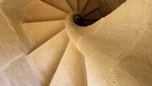 A spiral staircase with stone walls and a central column. - House with pool for 10 persons, central yet quiet area (Nadur)