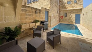 A stone building with a swimming pool, outdoor seating, and a barbecue area. - House with pool for 10 persons, central yet quiet area (Nadur)