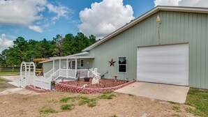 A building with a covered porch, a garage, and a fenced yard with a statue and a dog. - Green Acres House sleeps 6.  (Citra)