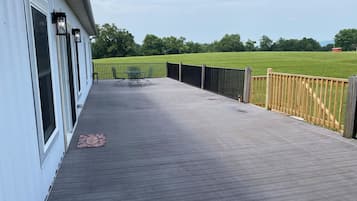 Enjoy outdoor dining or relaxation on this covered deck with a table and chairs.