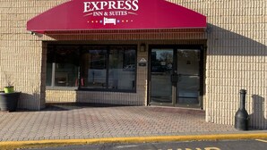 Un edificio de ladrillo con un toldo rojo que dice "EXPRESS INN & SUITES".