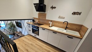 Una cocina moderna con encimera de madera, horno empotrado y un lavabo.