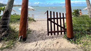 Un letrero de madera para ECO RESORT con vista a la playa.