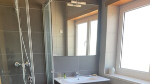 A modern bathroom with a glass-enclosed shower, a vanity with a sink, and a toilet. - Esperamos por si nas Suas Próximas Férias (Folhadal, Viseu, Portugal)