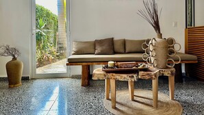 Un intérieur moderne avec un canapé, une table basse et un panneau mural portant l’inscription « PACHAMAYA ».