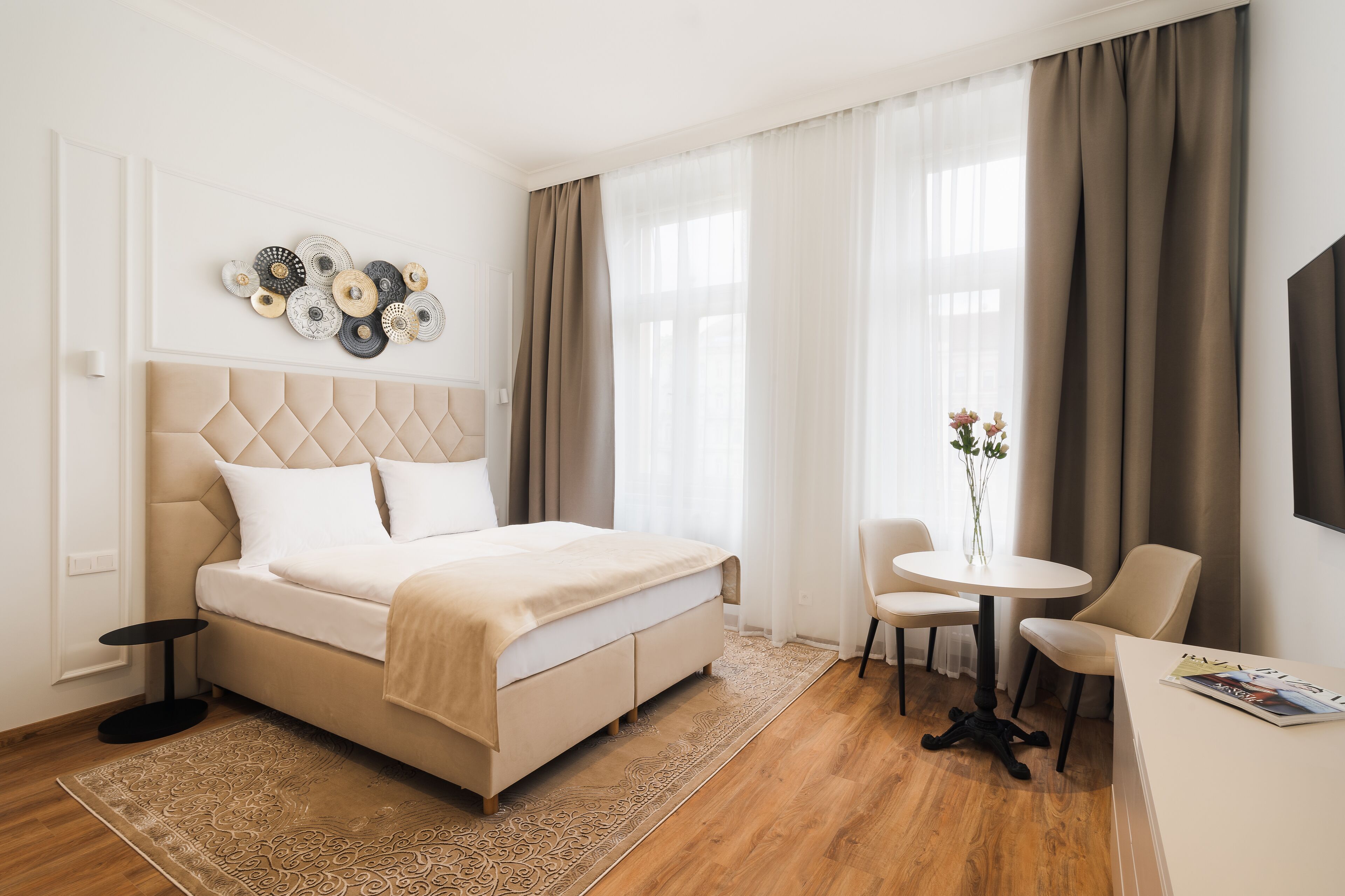 Una habitación de hotel con una cama, una mesa redonda y una silla.