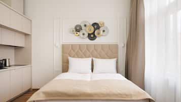 Un dormitorio ordenado con cama, un adorno en la pared y una zona de cocina.