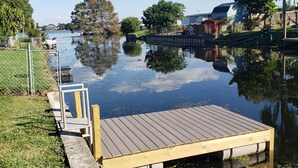 Un muelle de madera que se adentra en una masa de agua tranquila bajo un cielo despejado.