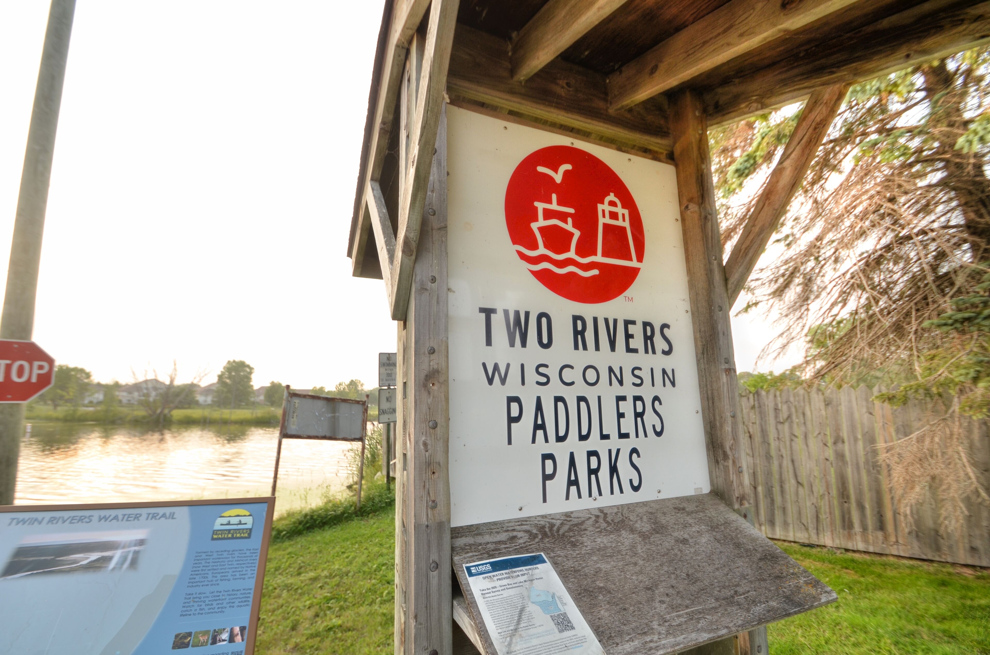 A wooden structure with a sign for Two Rivers Wisconsin Paddlers Parks.