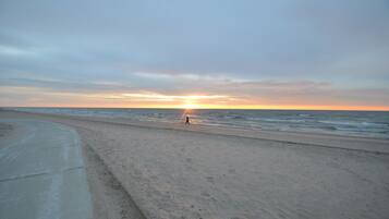 A beach with a concrete path and ocean view.