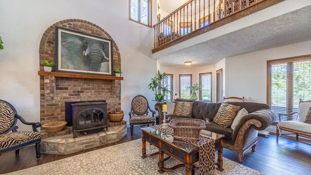 A spacious living room with a fireplace, a high ceiling, and a balcony. - A spacious finely-appointed luxury hideaway, nestled in the Ozark Mountains. (Lebanon)