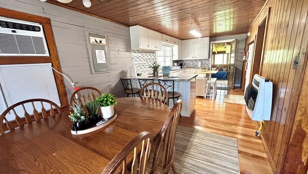 Un interior de madera con una mesa de comedor, sillas, una zona de cocina y un espacio de estar.