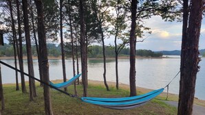 A hammock tied between trees by a lake. - Maples Lakefront Blessing w/ private boat dock/lake access kayaks & paddle boat (Sevierville)