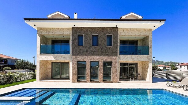 Una casa moderna de dos pisos con piscina delantera.