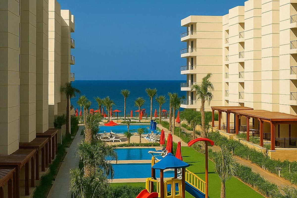 A resort with a pool area, palm trees, and a playground with slides.