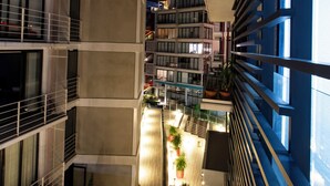 A modern building with multiple balconies, a glass atrium, and potted plants. - Modern, Cozy Apartment with Air Conditioning Encanto Cayala, Steps from Cayala (Ciudad de Guatemala)